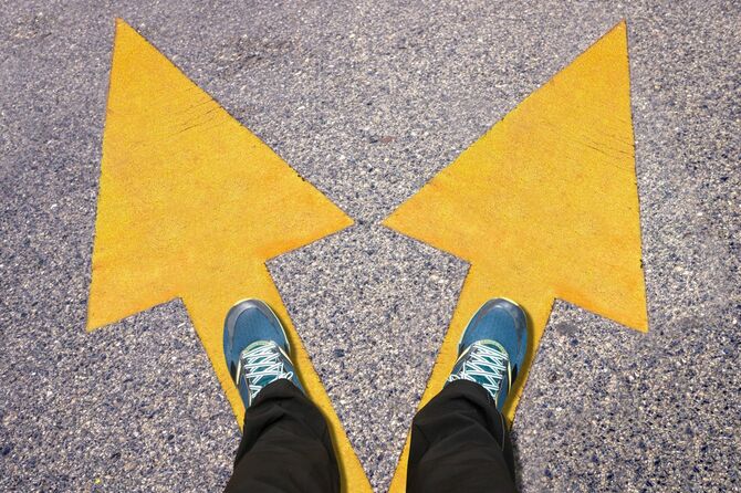 分かれた矢印に足を乗せる人