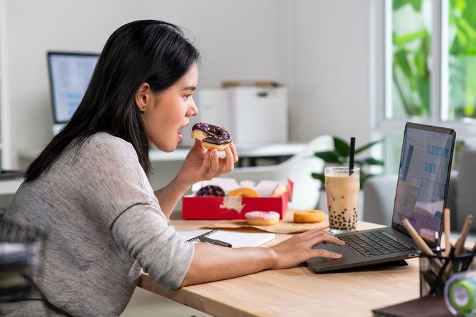 オフィスでドーナツを食べている女性
