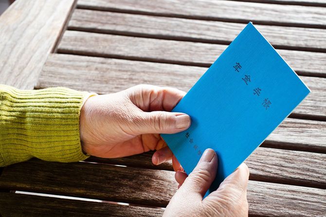 年金手帳を持つ人の手