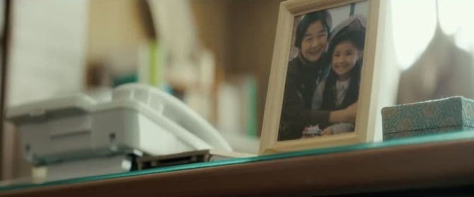 【図5】早織が座る位置からよく見えるように、伏見は写真立ての角度を調節する。