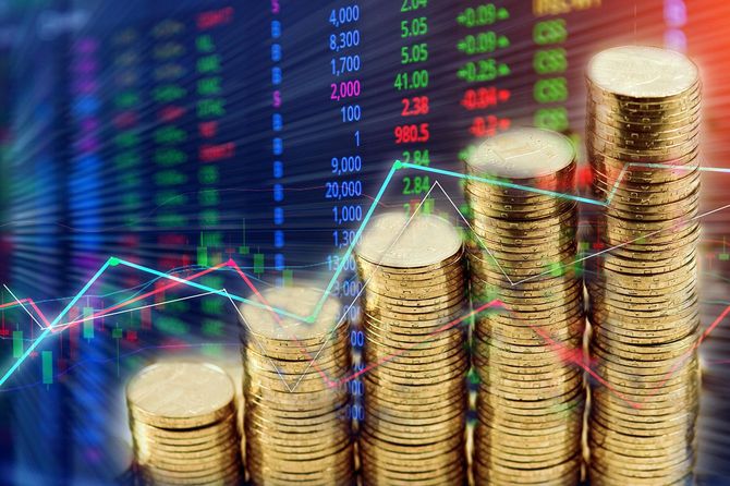 証券取引所画面の背景にコインのスタック