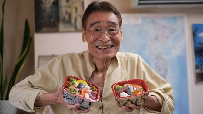 自慢の海鮮丼を手に取る大島会長