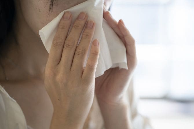 鼻をかんでいる女性