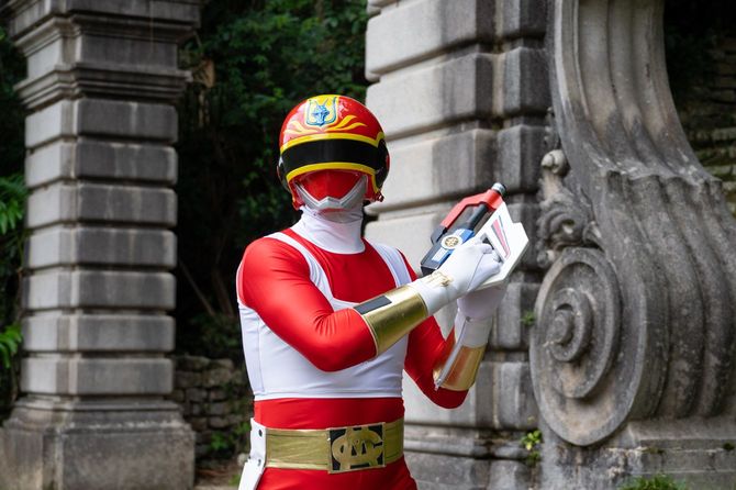 レッドドラゴンのスーツでポーズを決めるダニー・ツルギさん