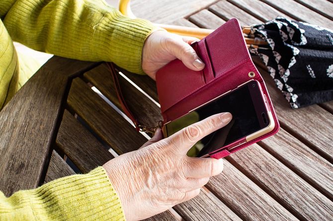 スマホを使用する高齢者の手元