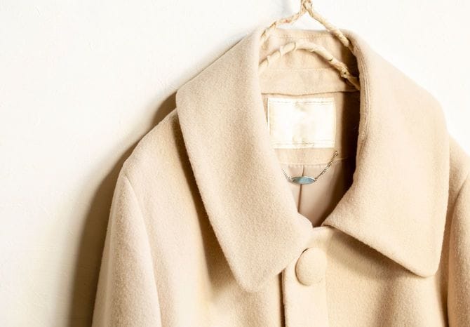 ハンガーにかけられた、ベージュのウールのコート