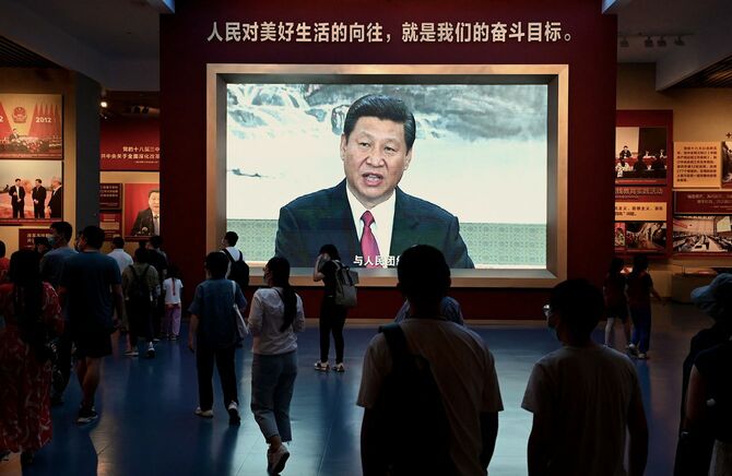 2022年9月4日、北京の中国共産党歴史展覧館で、中国の習近平国家主席を映したスクリーンの前を通り過ぎる人々。