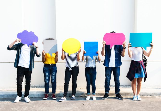 それぞれ吹き出しを手に掲げる若者たち