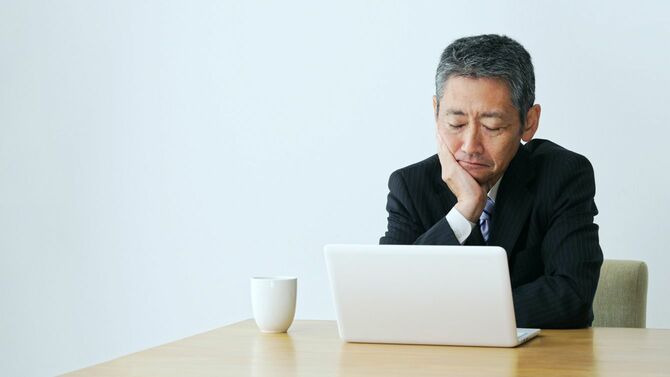 ラップトップの前で悩むビジネスマン