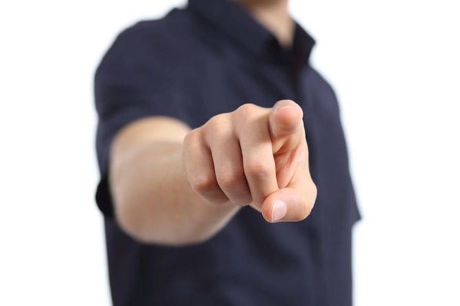 相対するこちらを指さす男性の手元