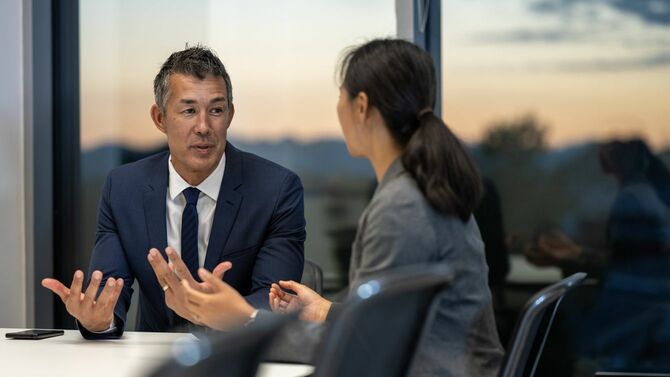 オフィスで話し合っている二人のビジネスパーソン