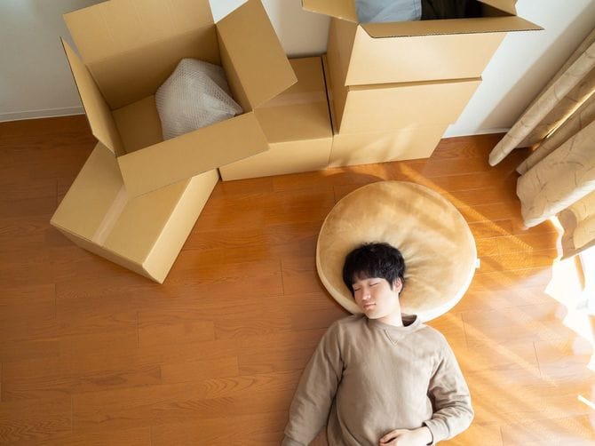 段ボールをあらかた開けて、昼寝する男性