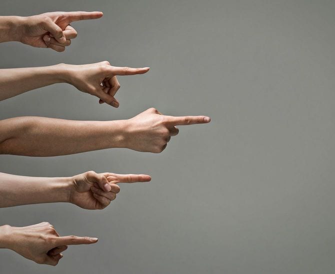 指をさして非難する複数の手