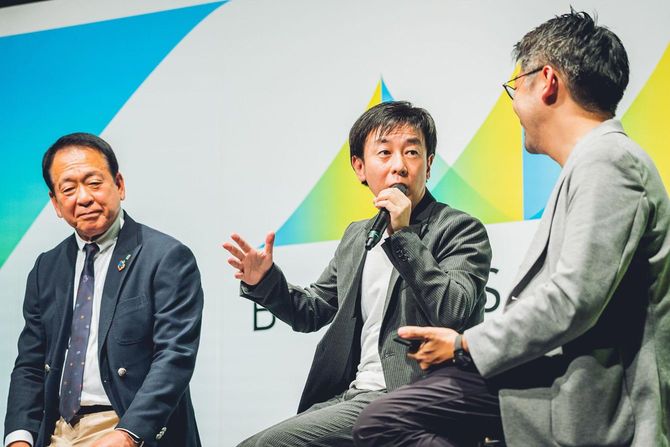 ステージで対談中のサイボウズ社長、青野氏(中央)
