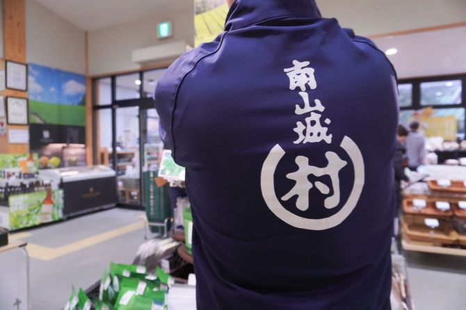 ユニフォームの背中には、「村」のしがらみを突破していく姿勢を表す会社のシンボルマーク。