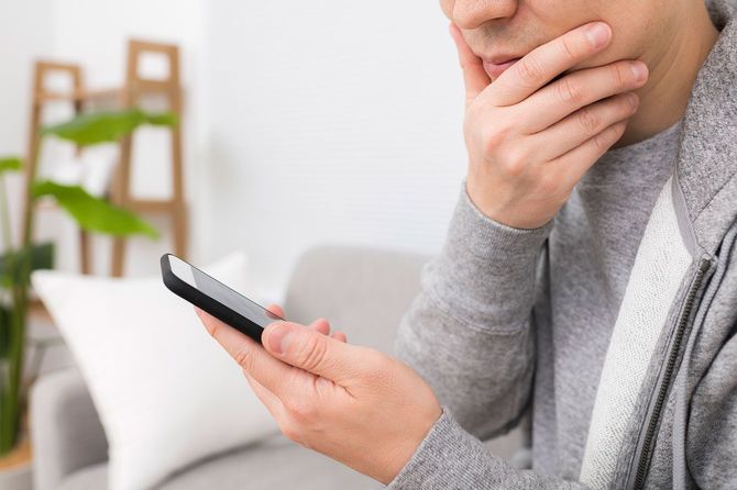 スマホを使用している中年男性