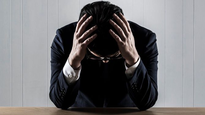 頭を抱えるビジネスマン
