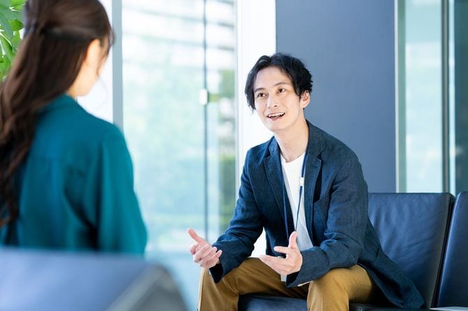 話をする2人のビジネスパーソン