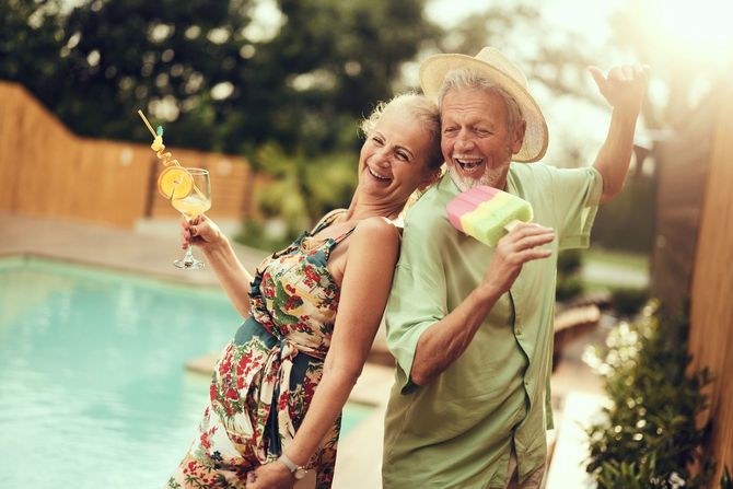 プールサイドで背中合わせに踊る屈託のない笑顔の老夫婦