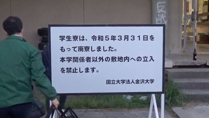 廃寮の看板を設置する大学職員