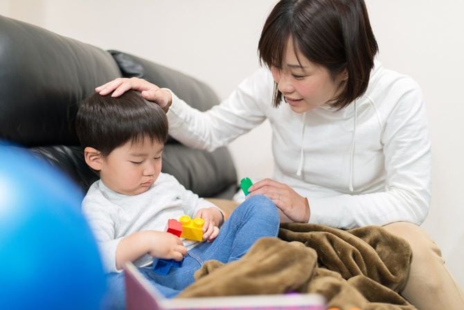 ソファの上の子に話しかける母