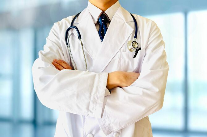 腕を組んでポーズをとっている男性医師