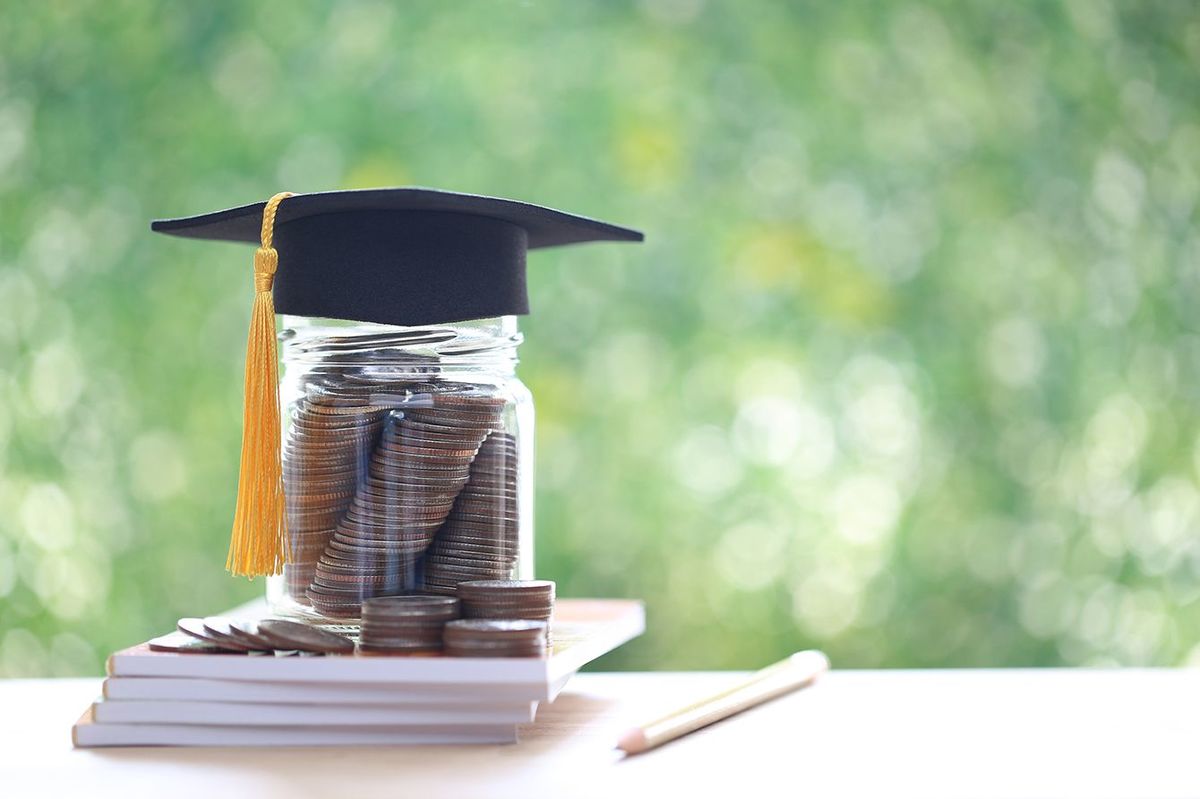 自然な緑の背景にガラス瓶にコインのお金の卒業帽子, 教育の概念のためのお金を節約