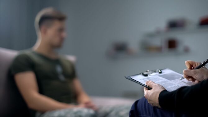 心理学者は悲しい男性兵士、PTSDとのセラピーセッション