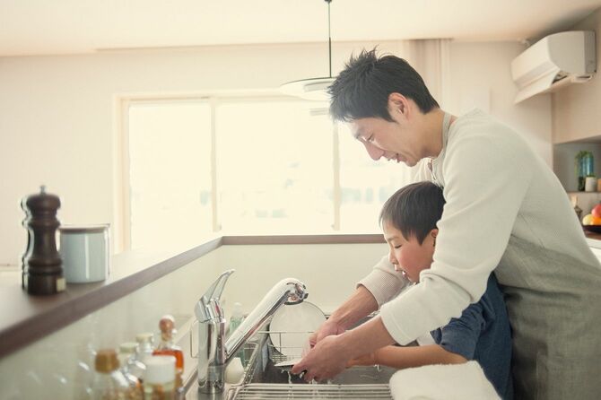 キッチンで皿を洗う父と息子