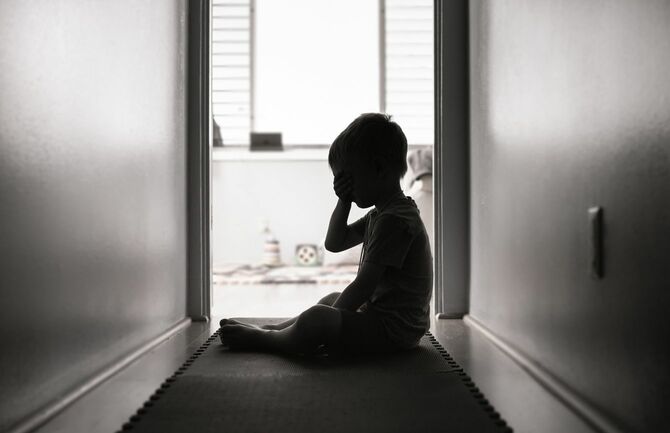 廊下に座り込み、泣いている男の子