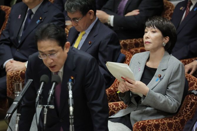 衆院予算委員会で岸田文雄首相（手前）の答弁を聞く高市早苗経済安全保障担当相（奥右）＝2023年11月21日、国会内