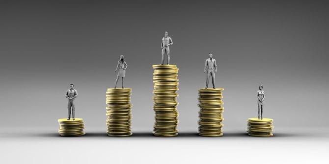 積み上げたコインにのった人形