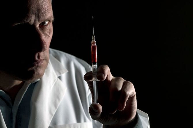 注射器を持ちこちらをにらむ医師