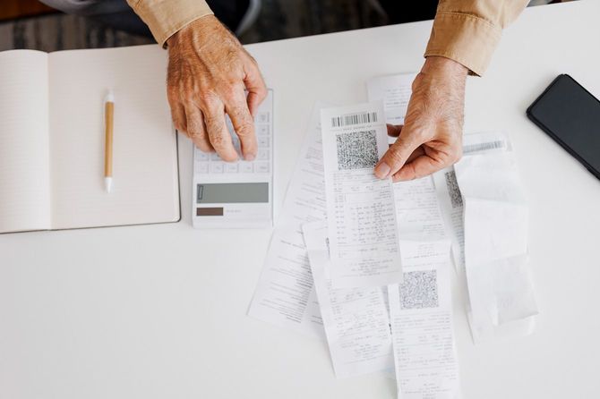 レシートを見ながら電卓で計算する人