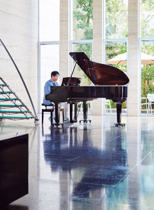 グランドピアノで坂本龍一の曲を弾く堂埜茂社長