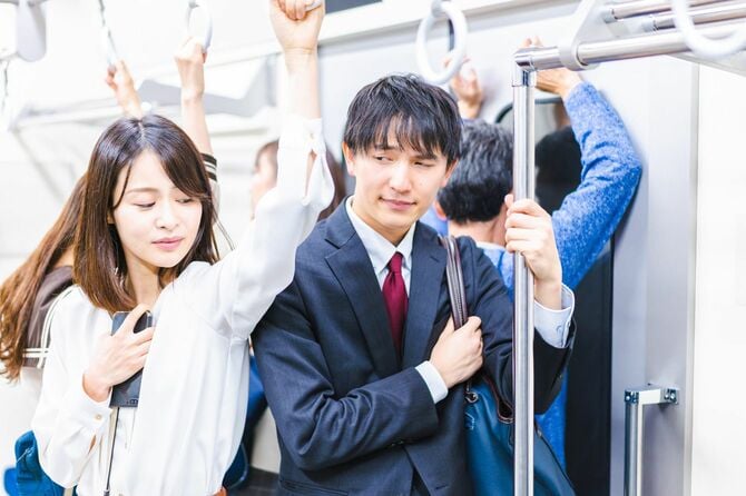 混雑した電車で通勤するビジネスパーソン