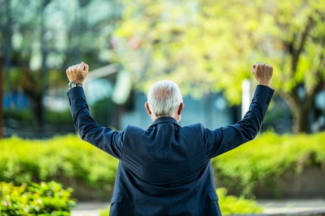 手を掲げて喜ぶシニアビジネスマン