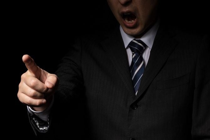 暗いところで指さし怒声をあげる男性