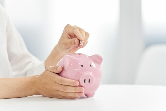 豚の貯金箱にお金を入れる人