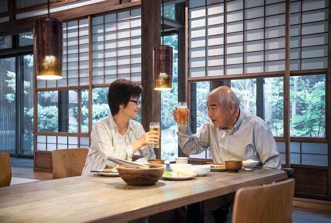日本人夫婦で乾杯するビールグラス