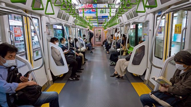 マスクを着けて、ソーシャルディスタンスを保って電車に乗る日本の人々（2020年5月8日）