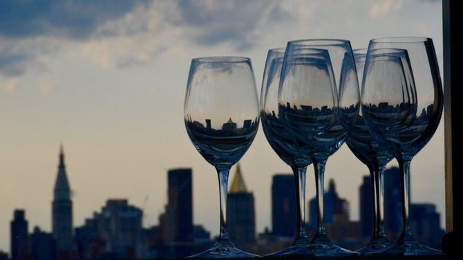 ニューヨークの街並みを背景に数脚のワイングラス