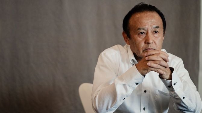 中年男性が両手を組んだ状態で考え込んでいる