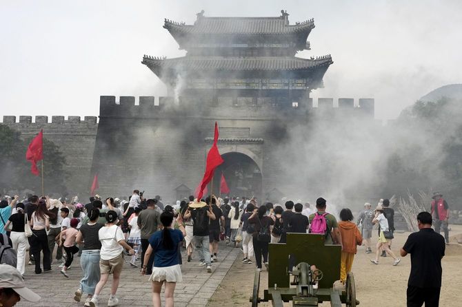 抗日戦争を追体験できるテーマパークで、日本軍の陣地に向かってなだれ込む客=2026年6月20日、中国山東省臨沂市(共同)