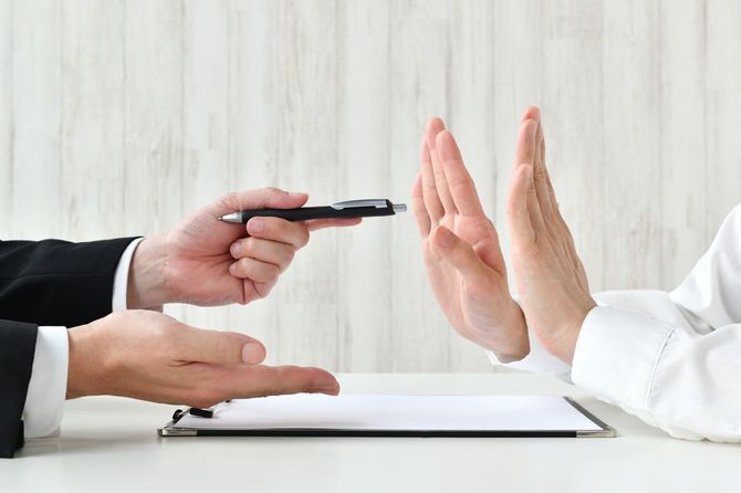 契約を勧めるビジネスマンと断る顧客