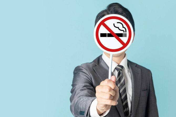 禁煙マークを手に持つ男