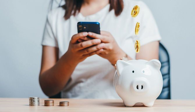 お金や投資を節約するために携帯電話アプリを使用する女性