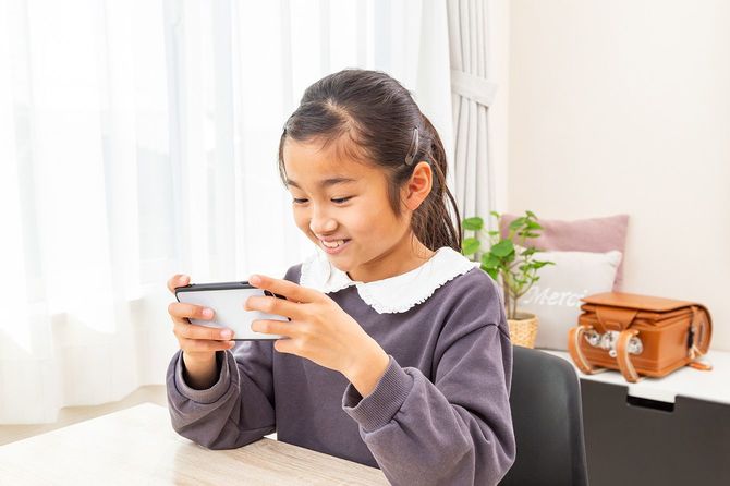 スマホを使用する子供