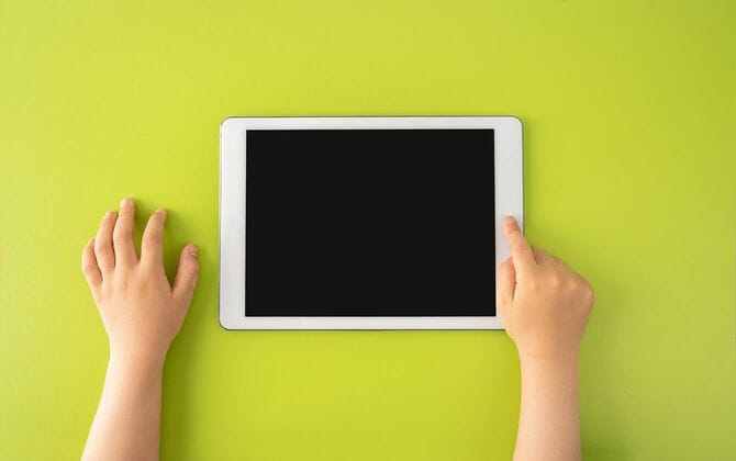 デジタルタブレットを使う小さな子供の手