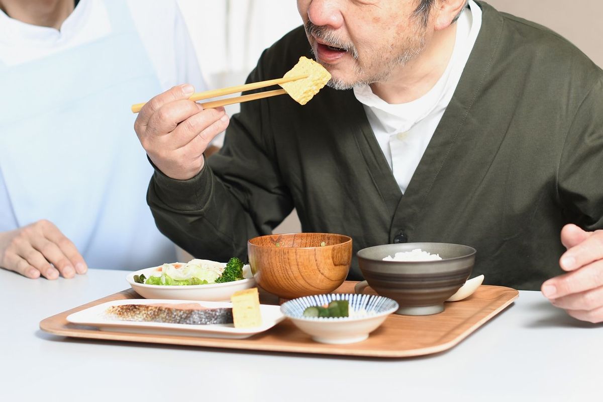 男性の食事を手伝う介護者